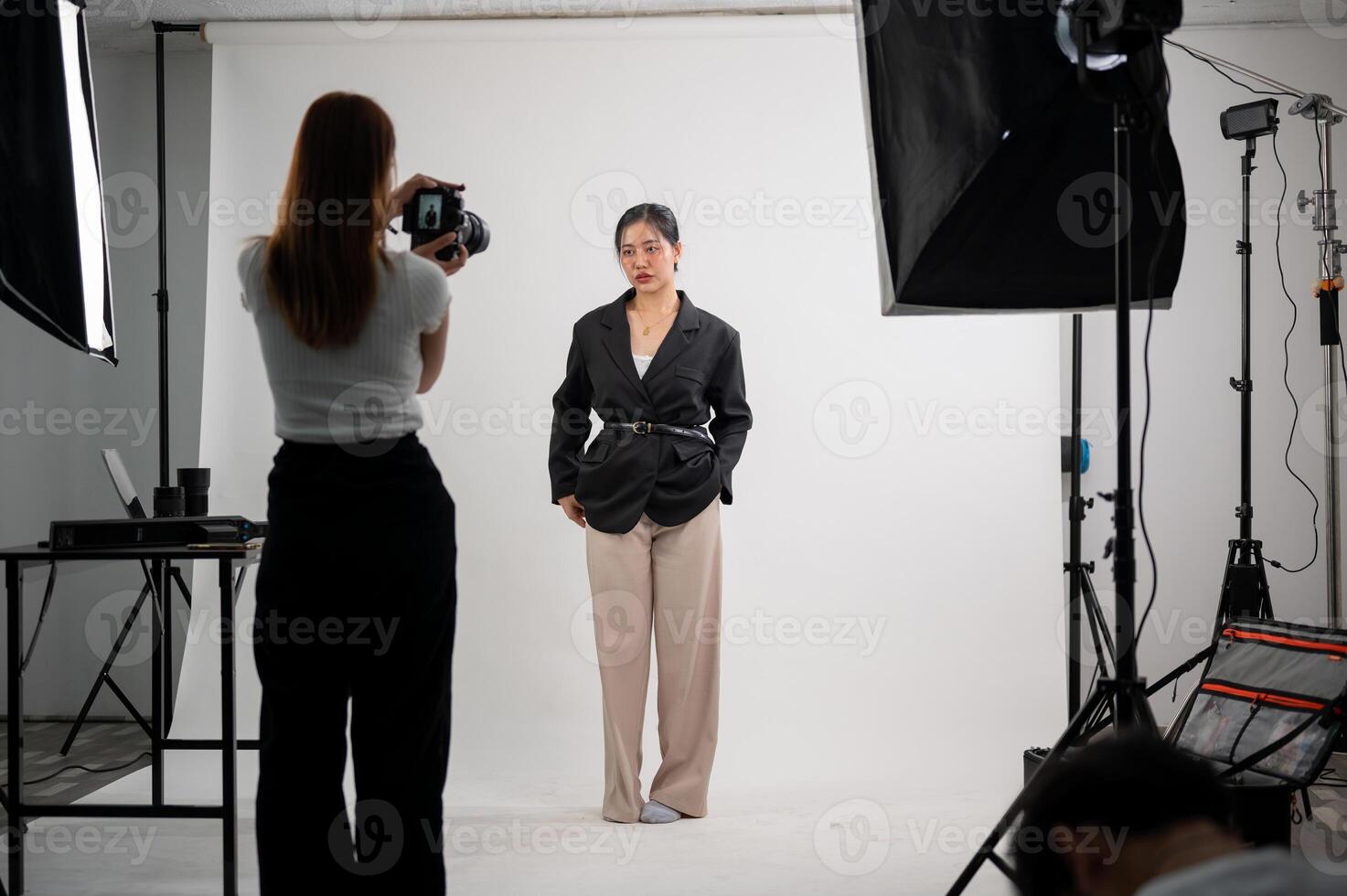 een aantrekkelijk Aziatisch vrouw model- is poseren voor een fotograaf in een modern mode studio. foto