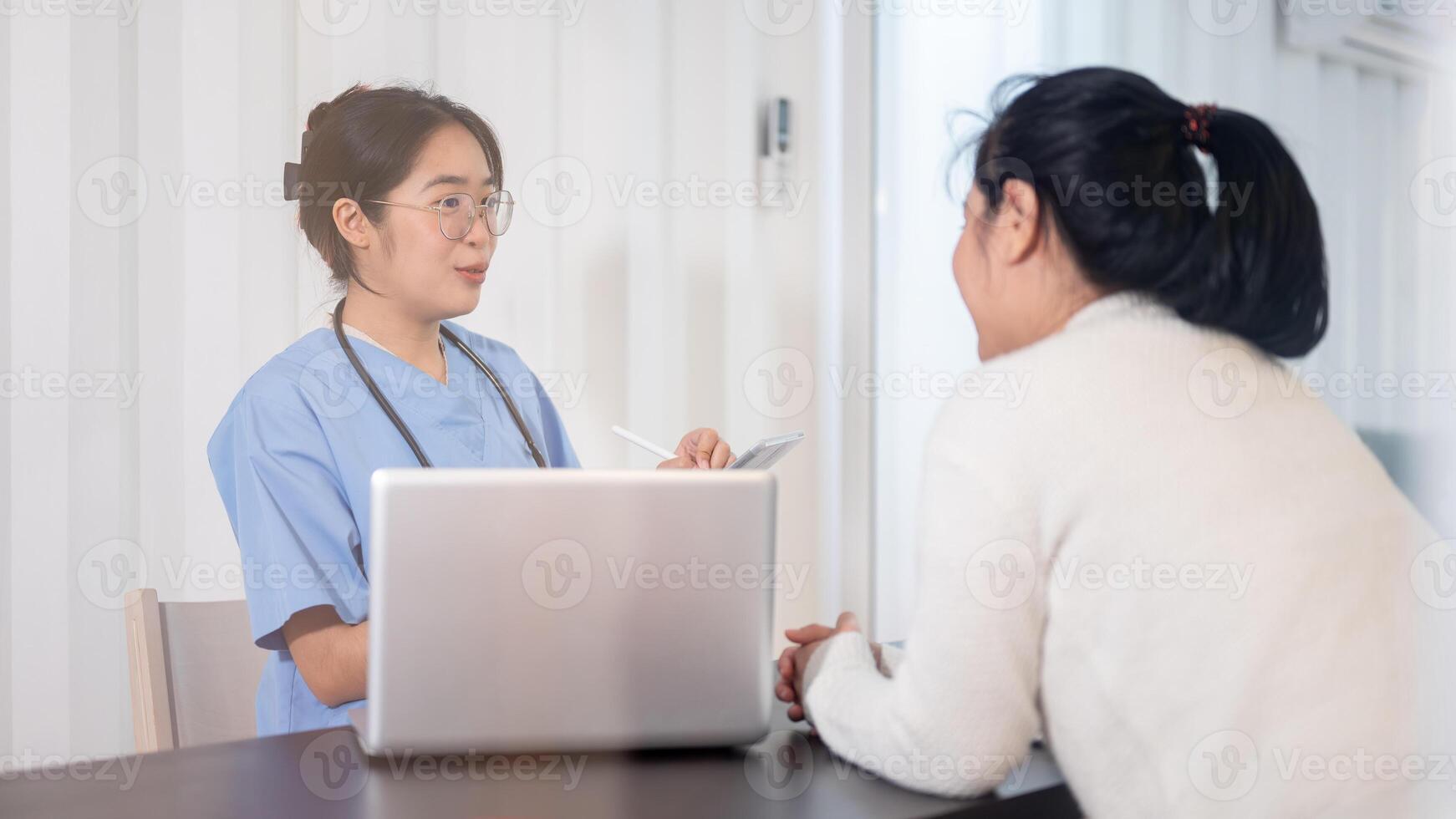 een professioneel Aziatisch vrouw dokter is overleg plegen een vrouw geduldig in de kantoor Bij de ziekenhuis. foto