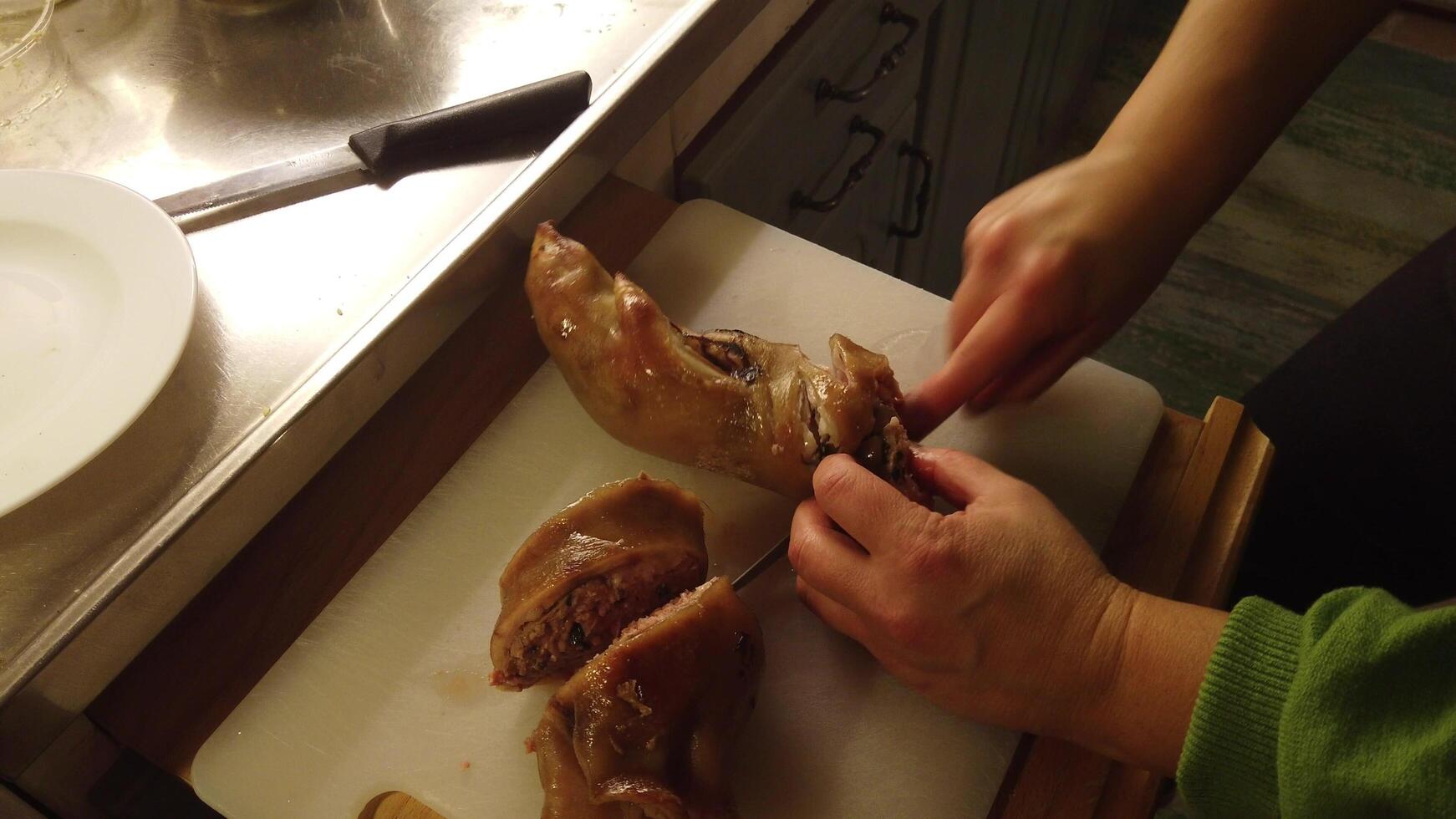 video van de snijdend van een gevuld en gebakken varkensvlees been foto