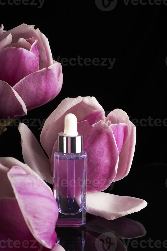 een fles van parfum met een roze bloem in de achtergrond. foto