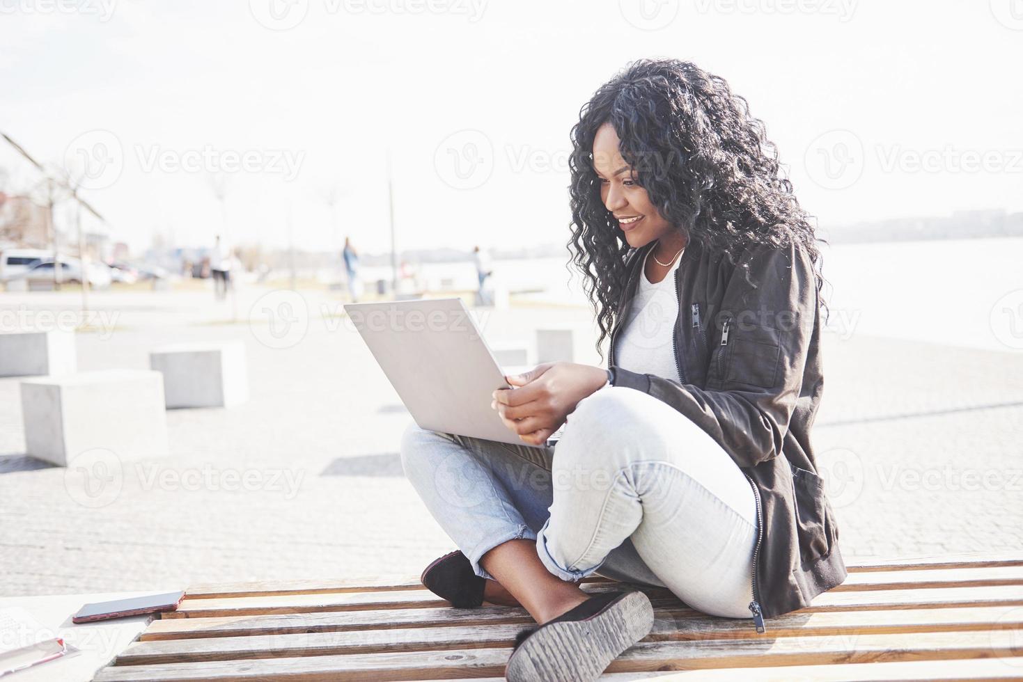 jonge vrouw op straat die aan laptop werkt foto