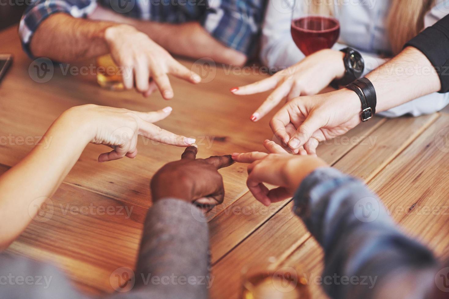 close-up bovenaanzicht van jonge mensen die hun handen in elkaar slaan. vrienden die een stervorm doen met vingers die eenheid en teamwork tonen foto