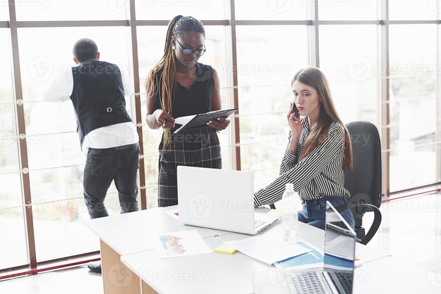 ieder doet zijn eigen werk. groep freelancers aan het werk in het ruime kantoor met grote ramen foto