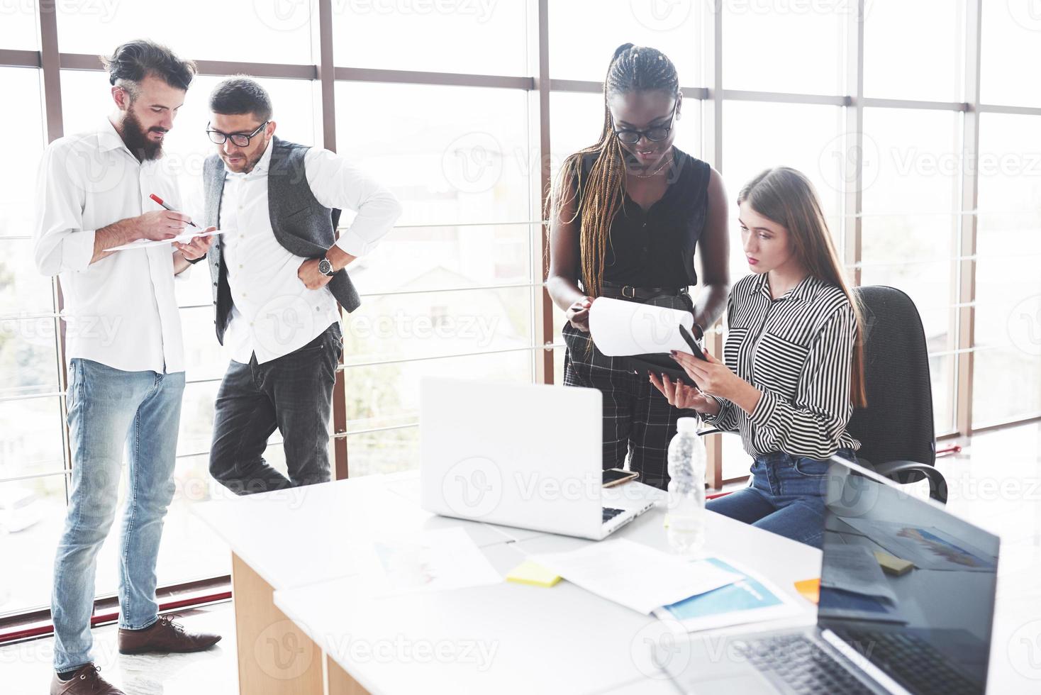 sta niet stil. groep freelancers aan het werk in het ruime kantoor met grote ramen foto