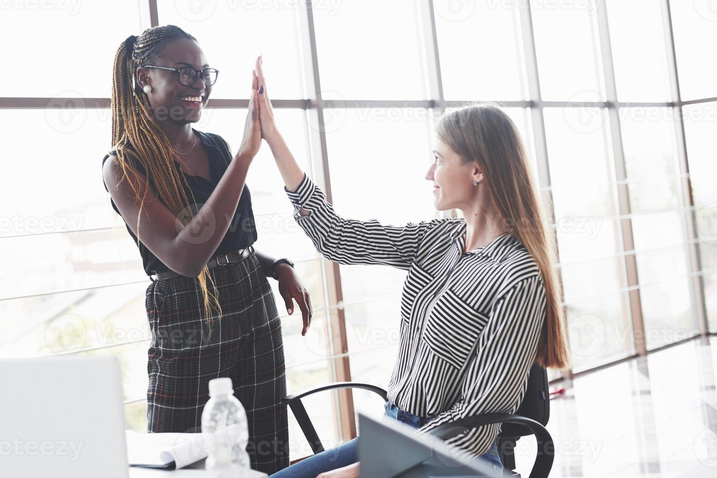 hoge vijf. twee multiraciale vrouwen zijn tevreden over het document dat ze hebben gemaakt foto