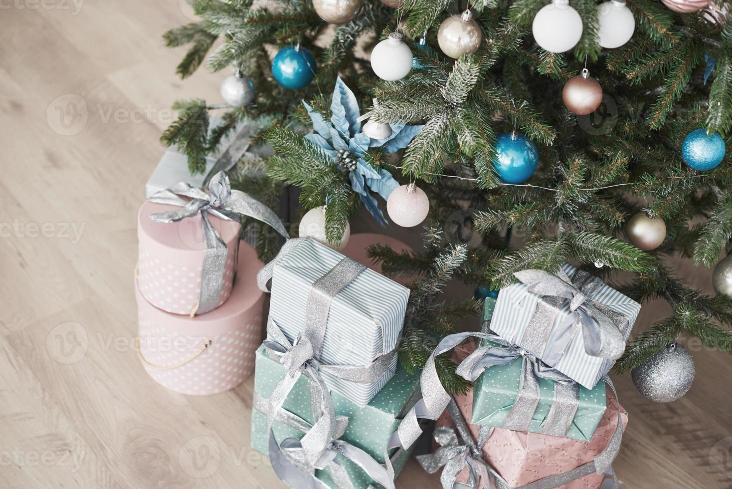 kerstboom met houten rustieke decoraties en cadeautjes eronder in loft interieur foto