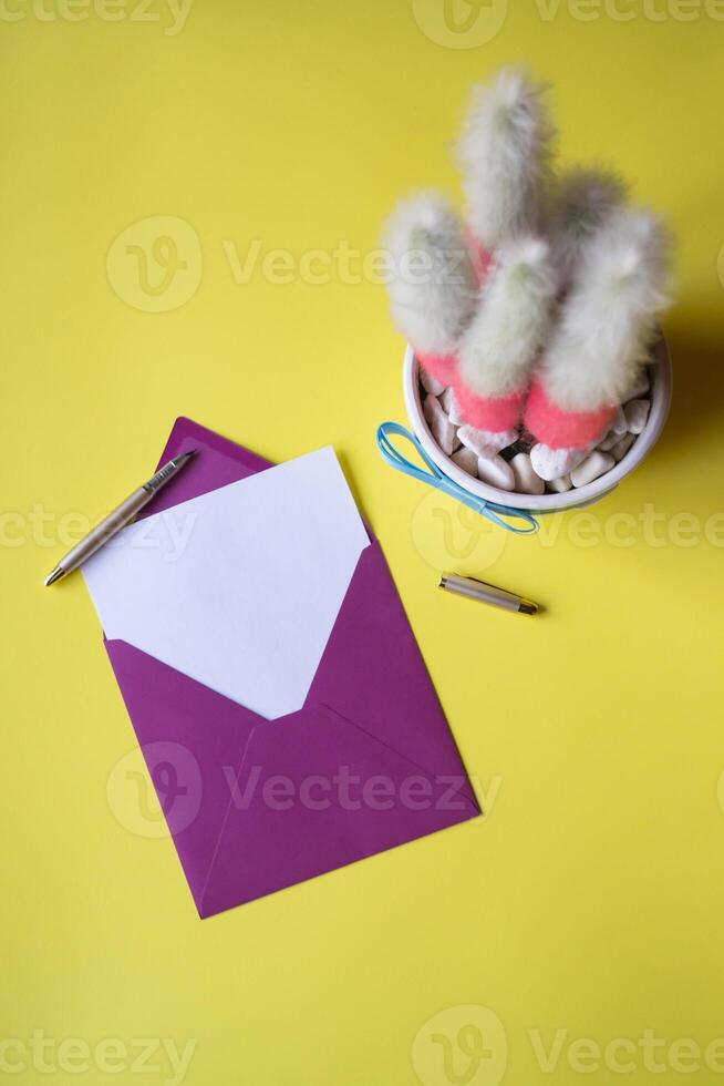 de envelop met Notitie blanco Aan de geel achtergrond in de buurt cactus. achtergrond met kopiëren ruimte. foto