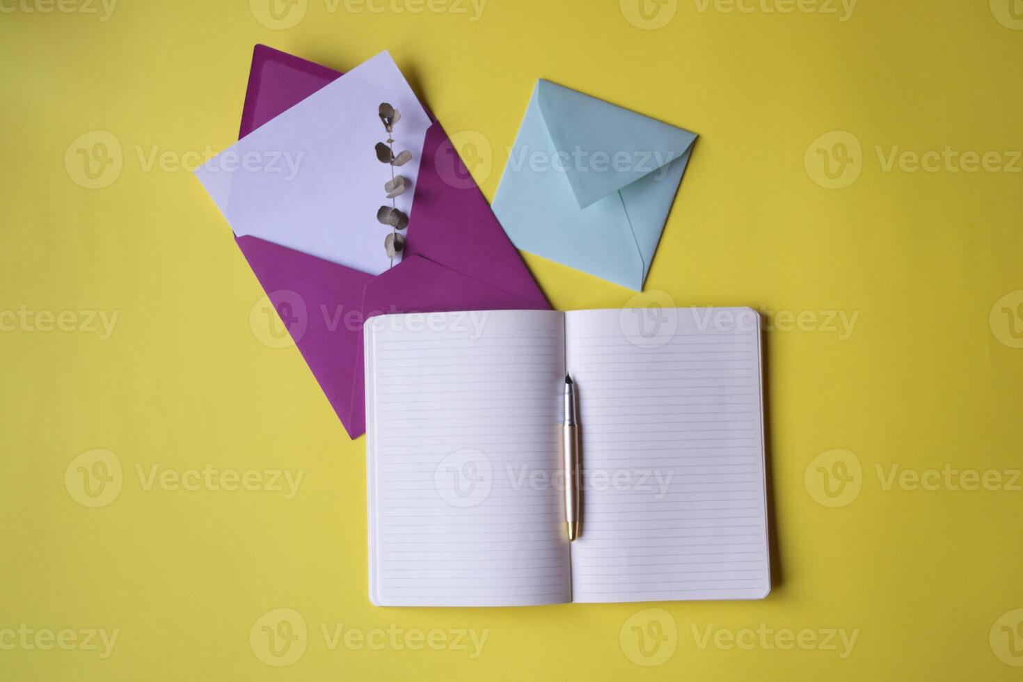 geopend notitieboekje en kleurrijk enveloppen met Notitie blanco Aan de geel achtergrond. achtergrond met kopiëren ruimte. foto