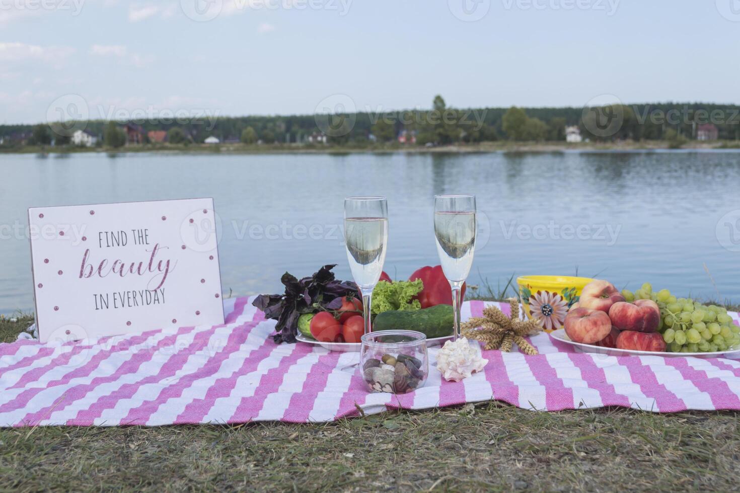 mooi picknick met fruit, groenten en bril van wijn in de buurt meer. foto