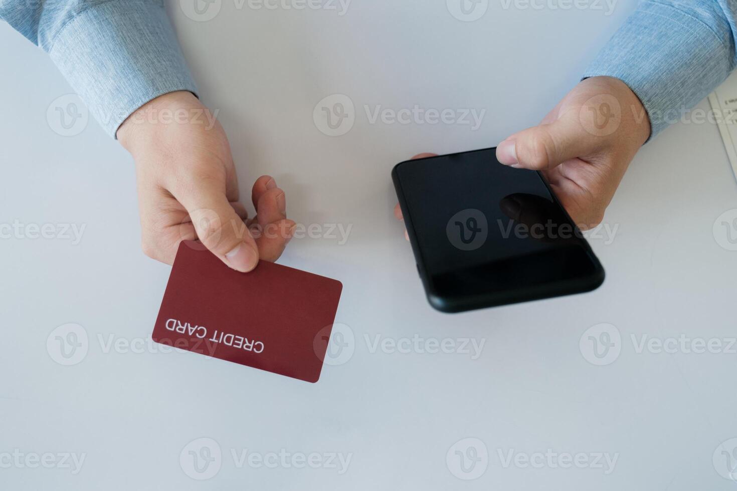 een Mens is gebruik makend van zijn telefoon naar betalen voor iets met een credit kaart foto