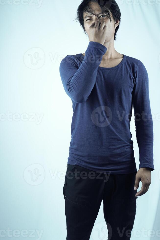 portret van gefrustreerd Mens knijpen neus- met walging Aan zijn gezicht omdat van slecht geur, geïsoleerd Aan wit achtergrond. foto