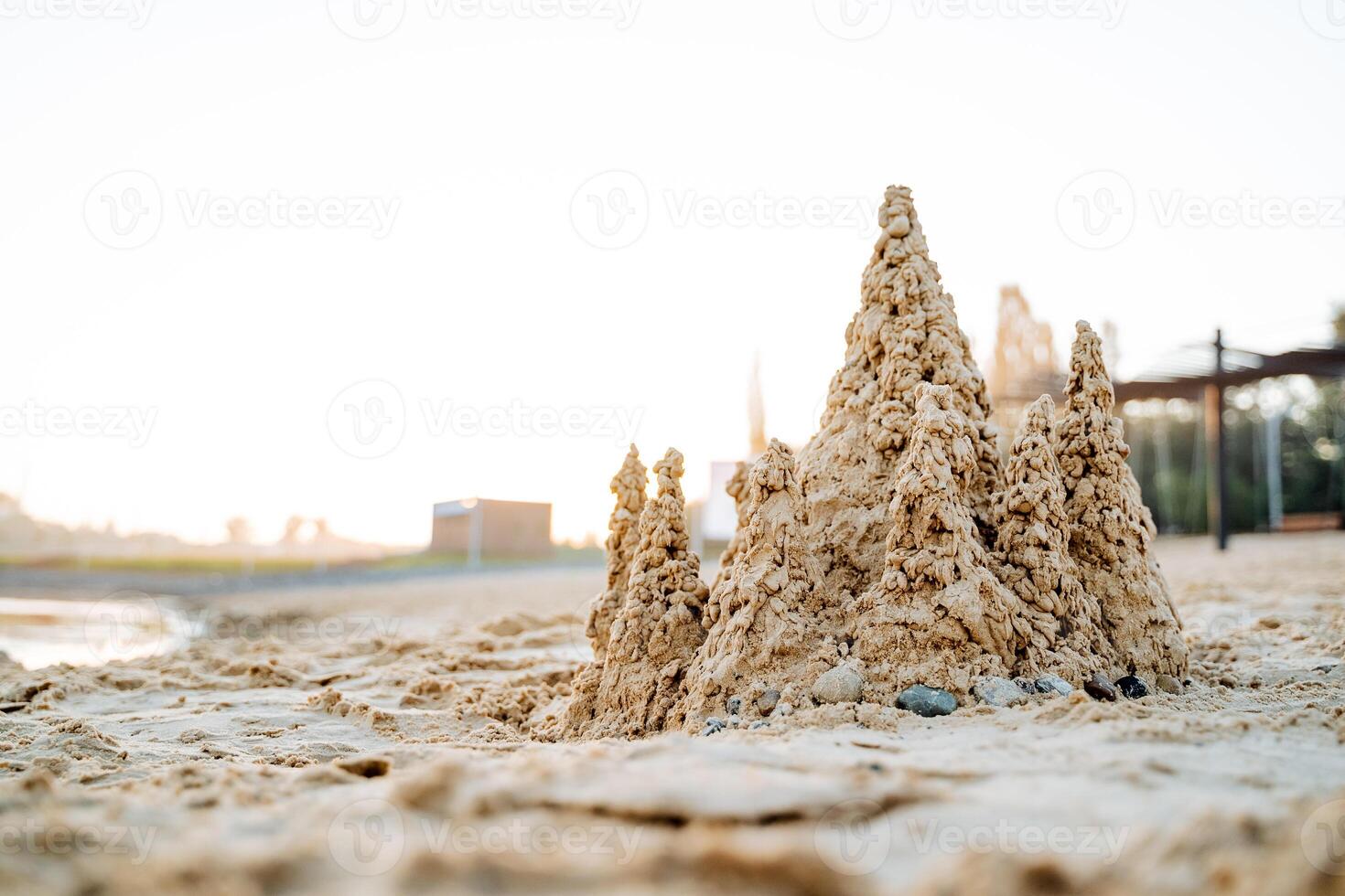 zand kasteel Aan de zee strand, kinderen pret naar Speel met nat zand, zand torens tegen de achtergrond van de zon, ochtend- dageraad Aan de zee, kust vakantie foto