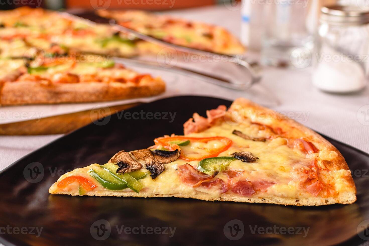 detailopname een stuk van groot heerlijk pizza met paddestoelen, pijper, kaas, ham geserveerd Aan de zwart bord buiten in Grieks taverne. tafel instelling. klant onderhoud. middellandse Zee keuken foto