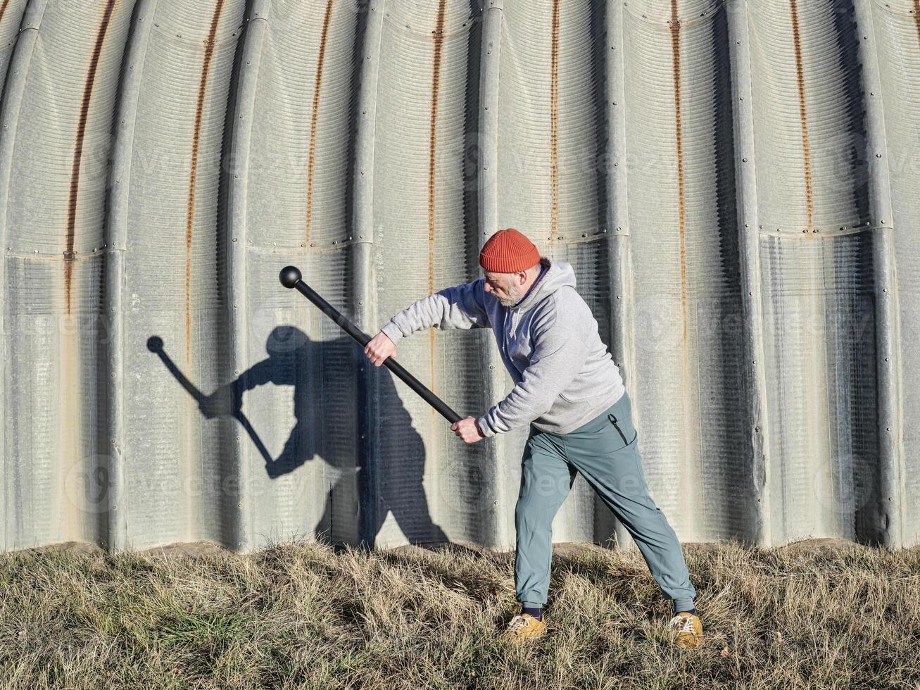 senior atletisch mannetje is oefenen met een staal foelie foto