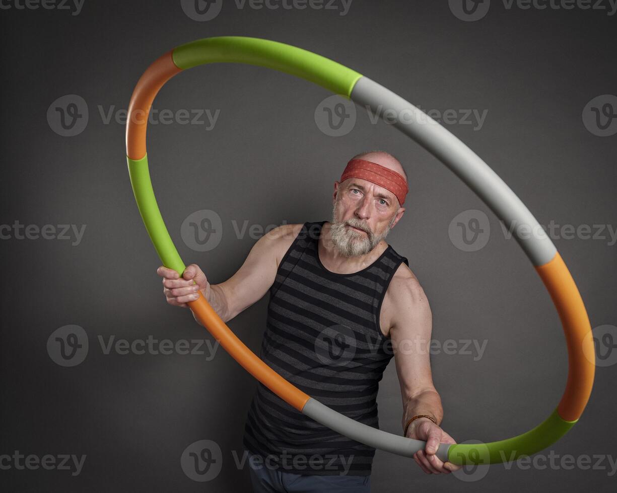 senior Mens is oefenen met een gewogen hula hoepel foto