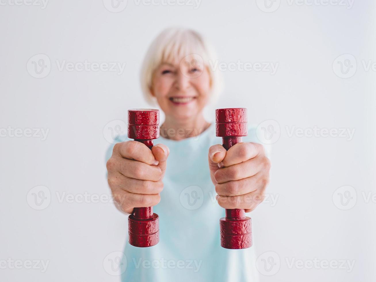 senior vrolijke vrouw sporten met halters. anti-leeftijd, sport, gezond levensstijlconcept foto