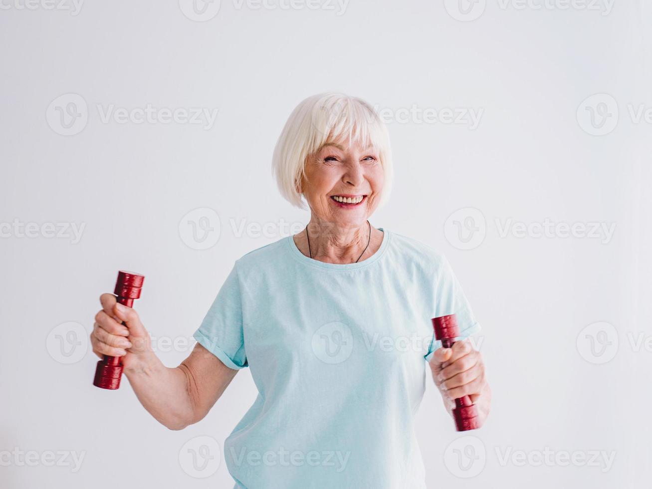 senior vrolijke vrouw sporten met halters. anti-leeftijd, sport, gezond levensstijlconcept foto