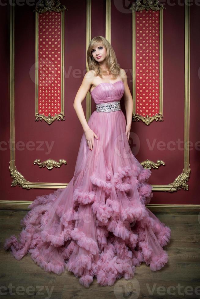 portret van jonge mooie vrouw in lange roze jurk foto