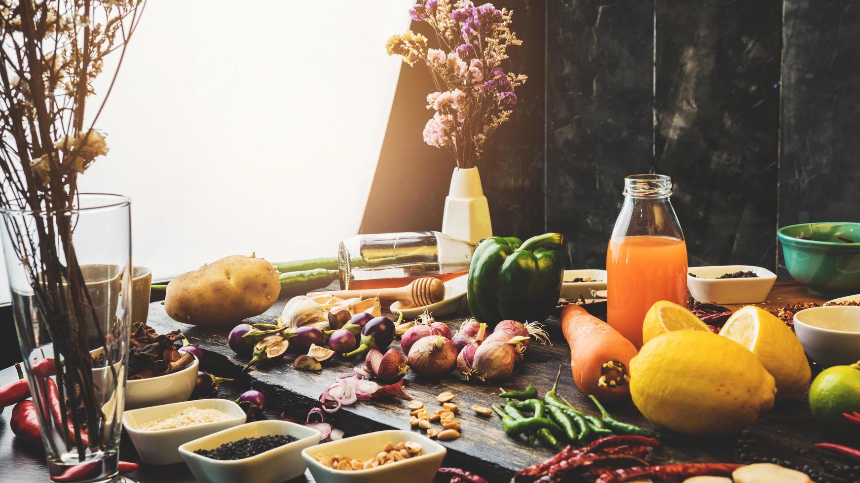 gezonde voeding kruiden specerijen voor gebruik als kookingrediënten op een houten ondergrond met verse biologische groenten op hout. het concept van voedselingrediënten met variatie op de rustieke tafel. foto