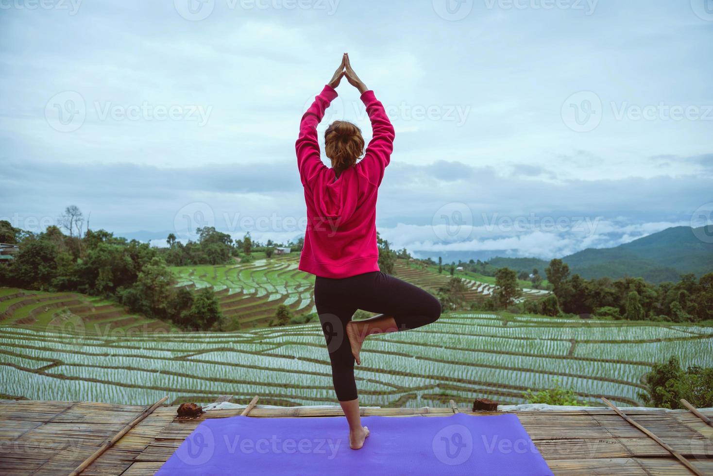 Aziatische vrouw ontspannen in de vakantie. spelen als yoga. op het natuurlijke veld van het balkonlandschap. papongpieng in thailand. foto
