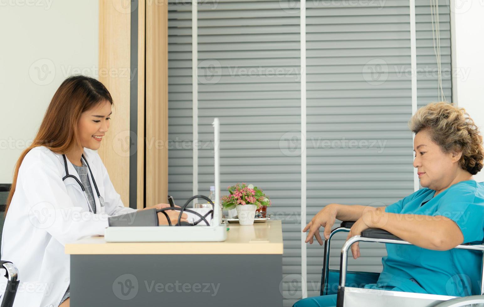 vrouwelijke artsen voeren ziektetests uit en geven medisch advies aan oudere patiënten die worden behandeld. foto