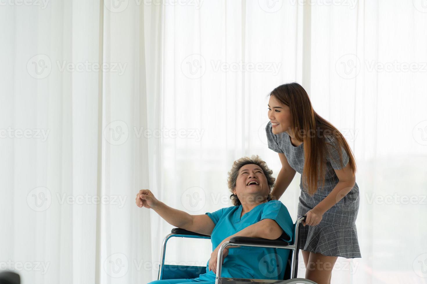 dochter van een oudere patiënt die de moeder verzorgt en aanmoedigt na behandeling door de arts. foto