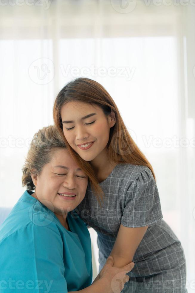 dochter van een oudere patiënt die de moeder verzorgt en aanmoedigt na behandeling door de arts. foto