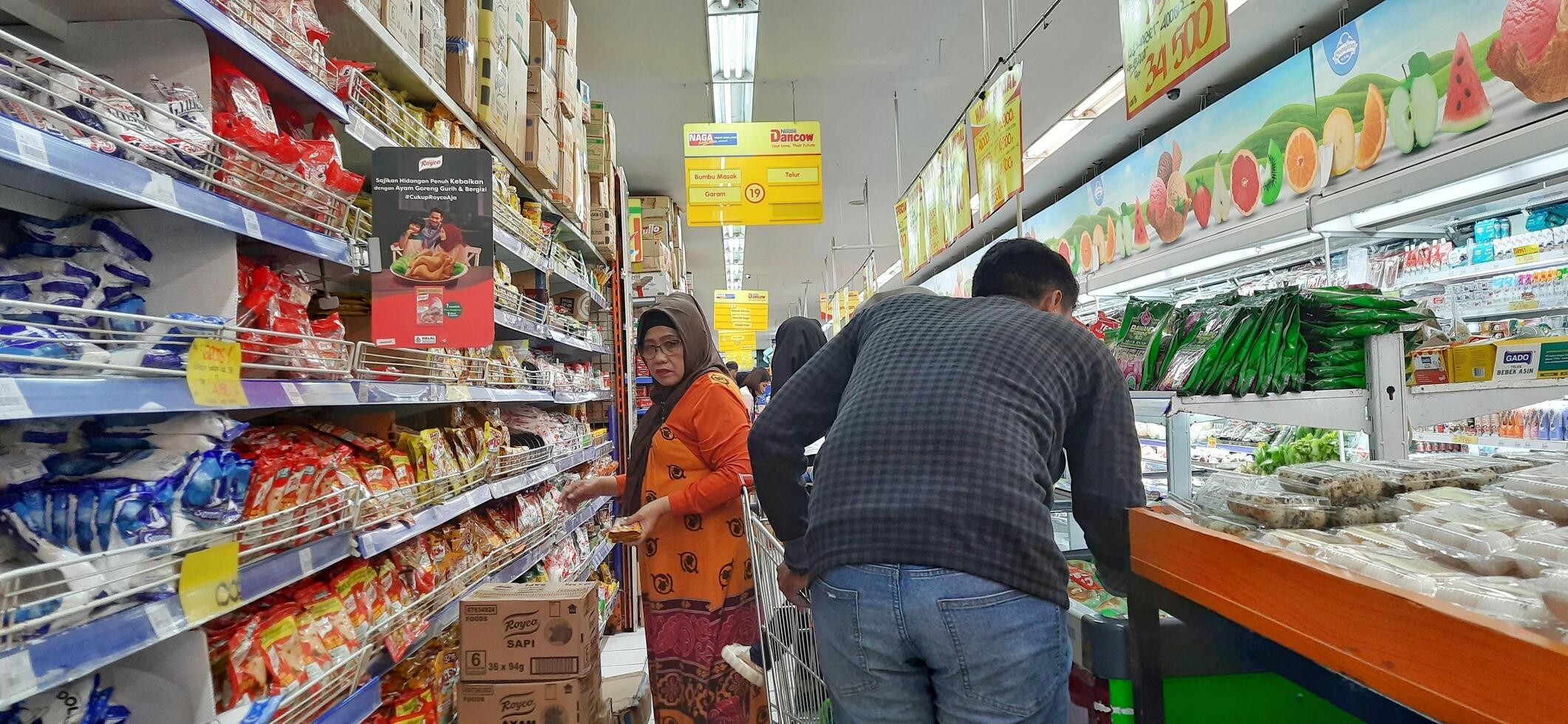 klant kiezen divers boodschappen producten in kruidenier op te slaan. supermarkt concept. bekasi, west Java, Indonesië - maart 8 2024 foto