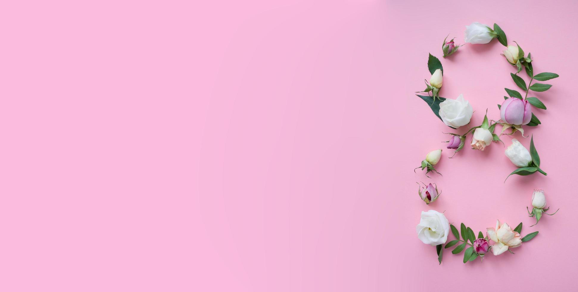 figuur 8 gemaakt van verschillende bloemen op roze achtergrond foto