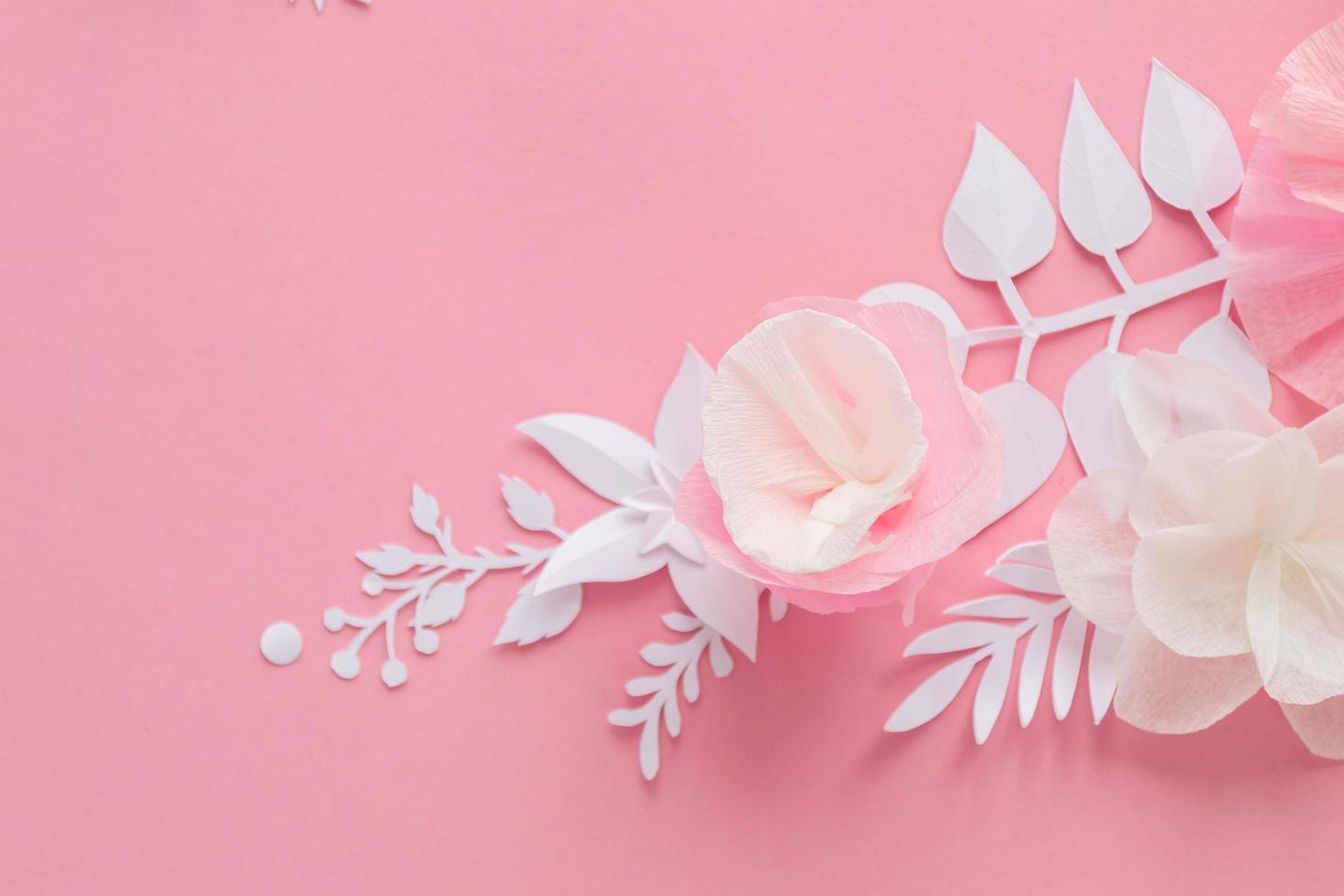 witte en roze papieren bloemen op de roze achtergrond foto