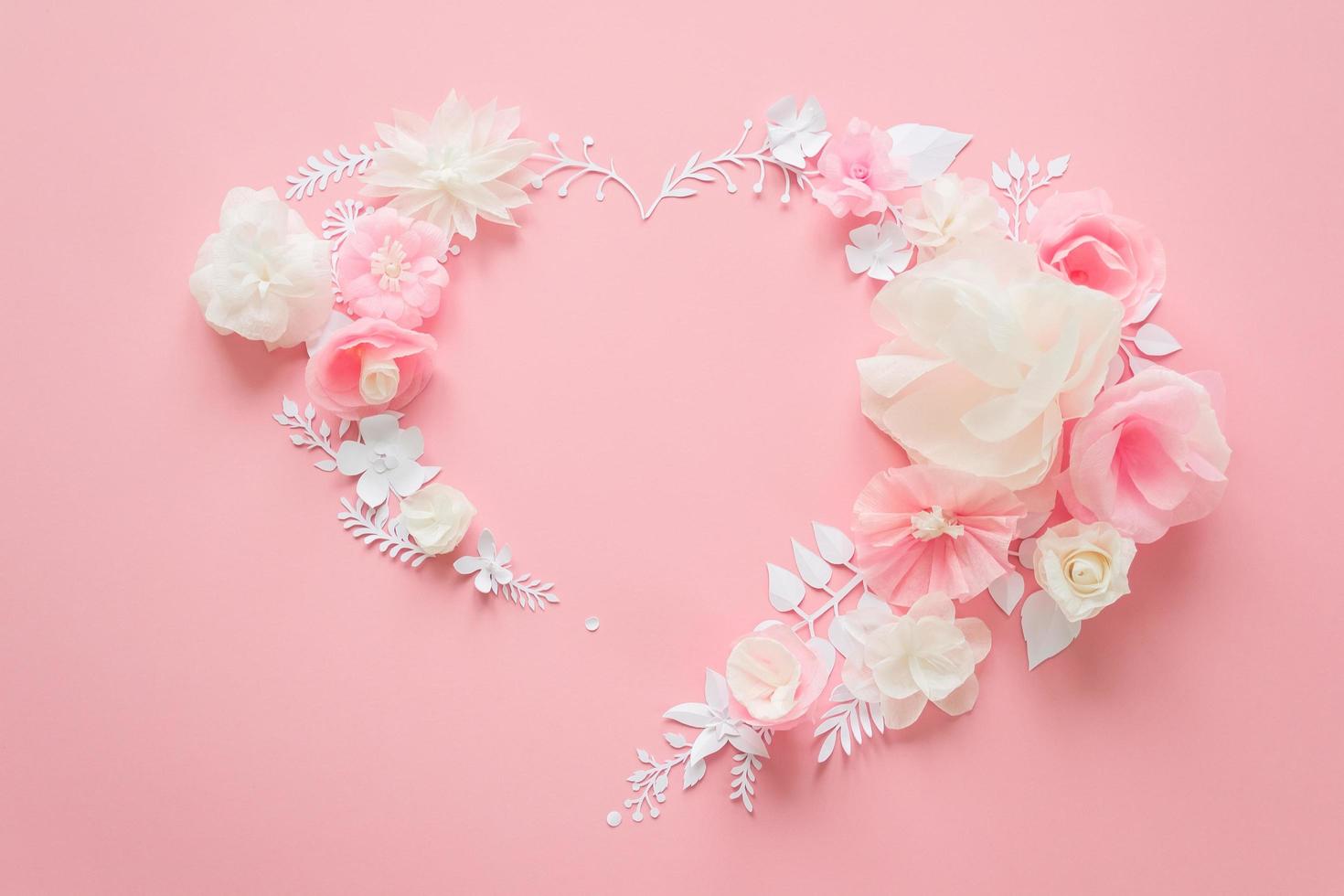 witte en roze papieren bloemen op de roze achtergrond foto