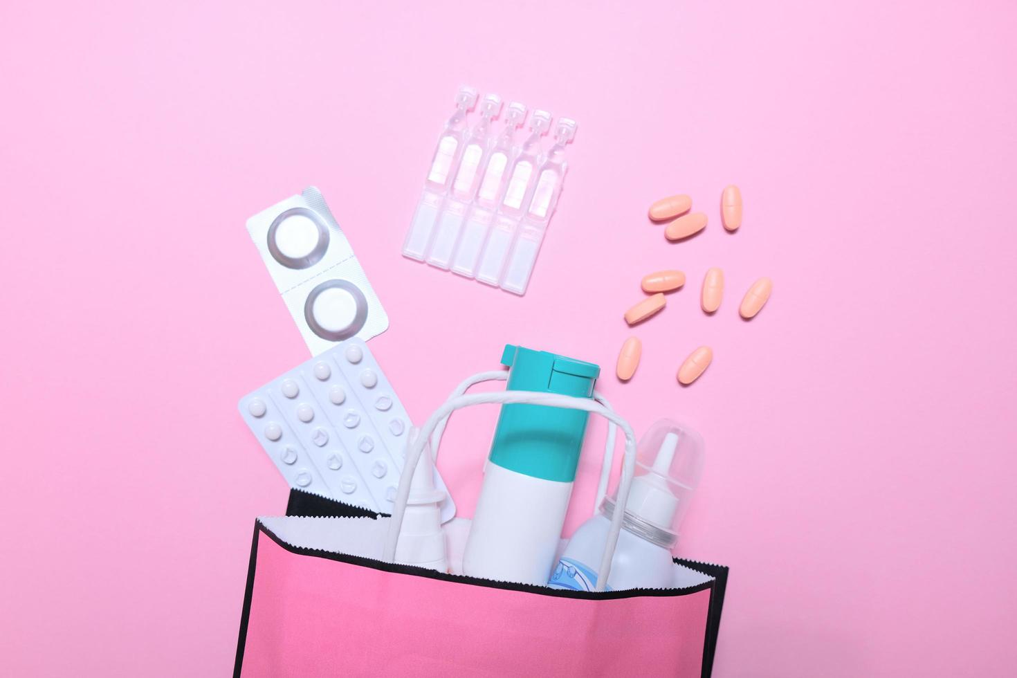koud seizoen, een pakje medicijnen op een roze achtergrond. foto