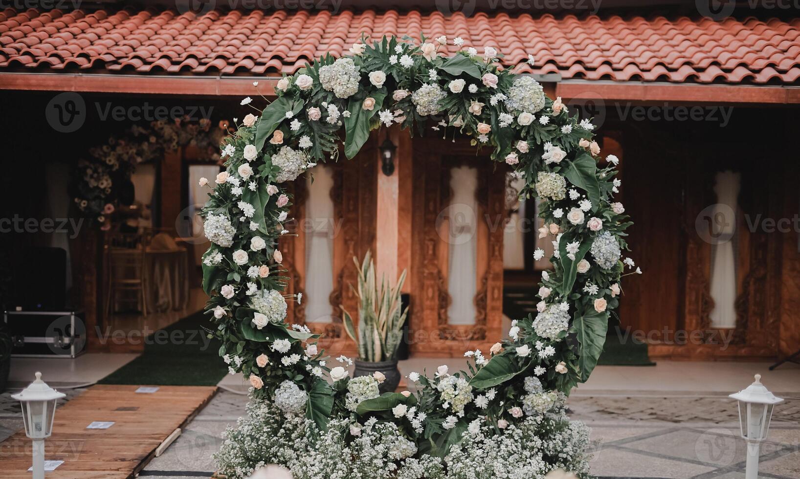 bruiloft boog Bij een locatie. ronde bloemen boog. de neiging in bruiloft banket zalen is voor bogen versierd met bloemen en groenen, tegen de backdrop van traditioneel Javaans gebouwen. foto