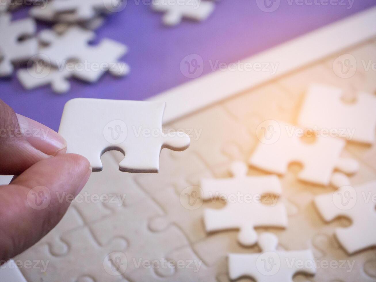 detailopname van handen vrouw Holding Verbinden decoupeerzaag puzzel met zonlicht effect. ruimte voor tekst foto