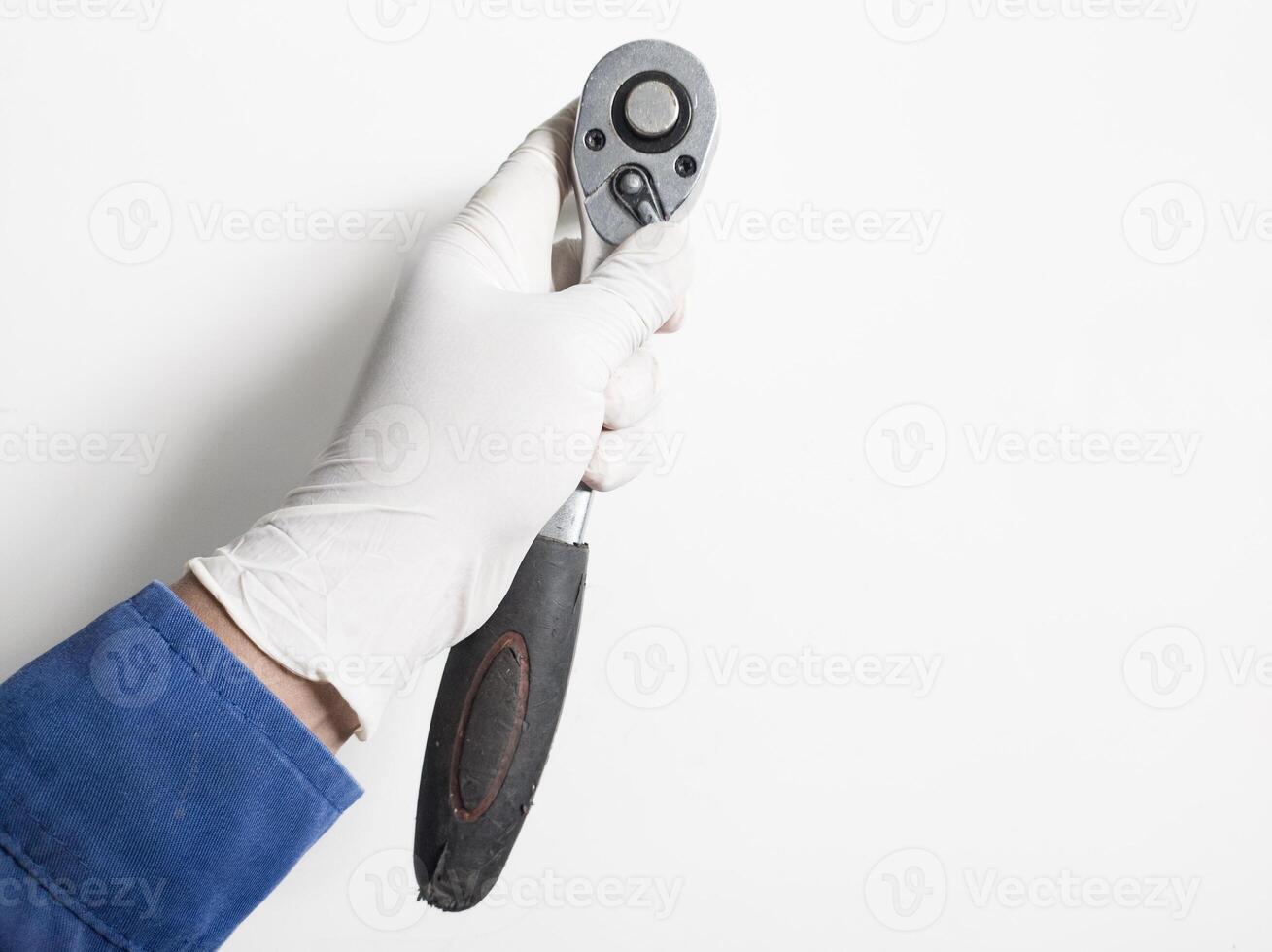 man's hand- met handschoenen houdt een ratel moersleutel geïsoleerd Aan wit achtergrond, mechanisch gereedschap moersleutel concept. foto