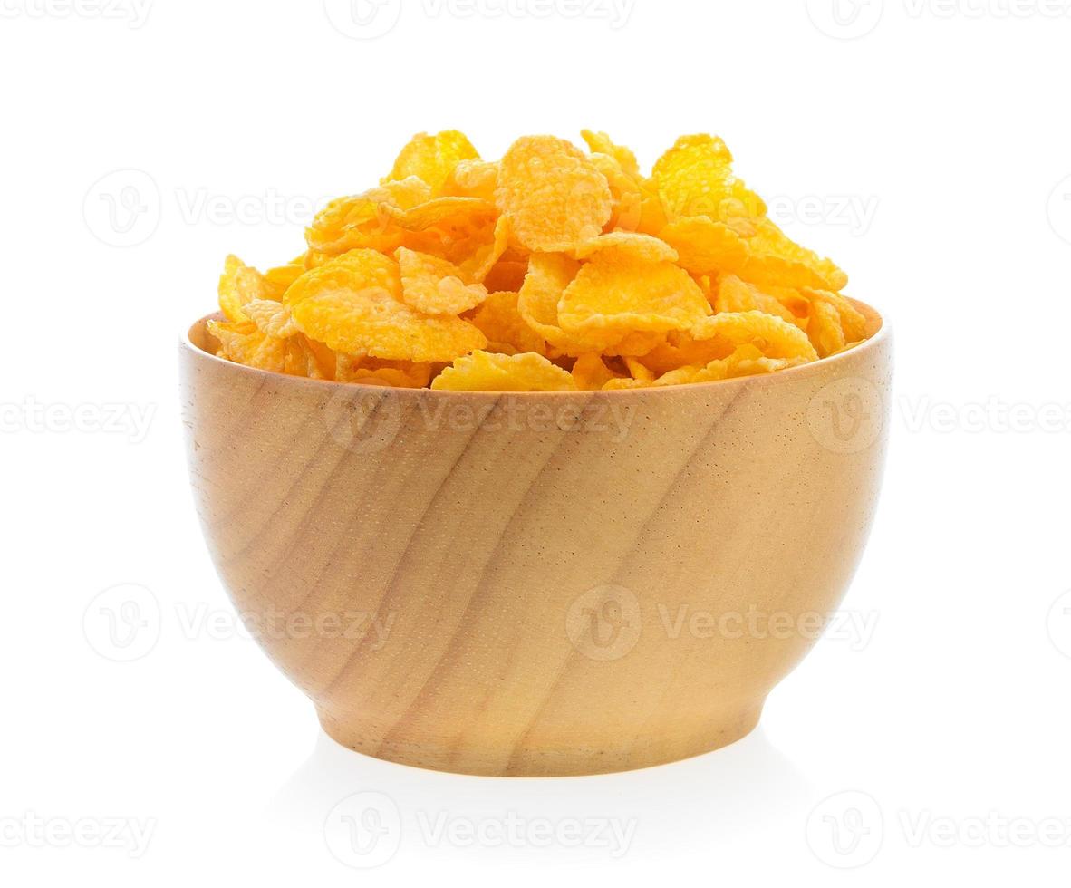 Cornflakes in houten kom die op witte achtergrond wordt geïsoleerd foto