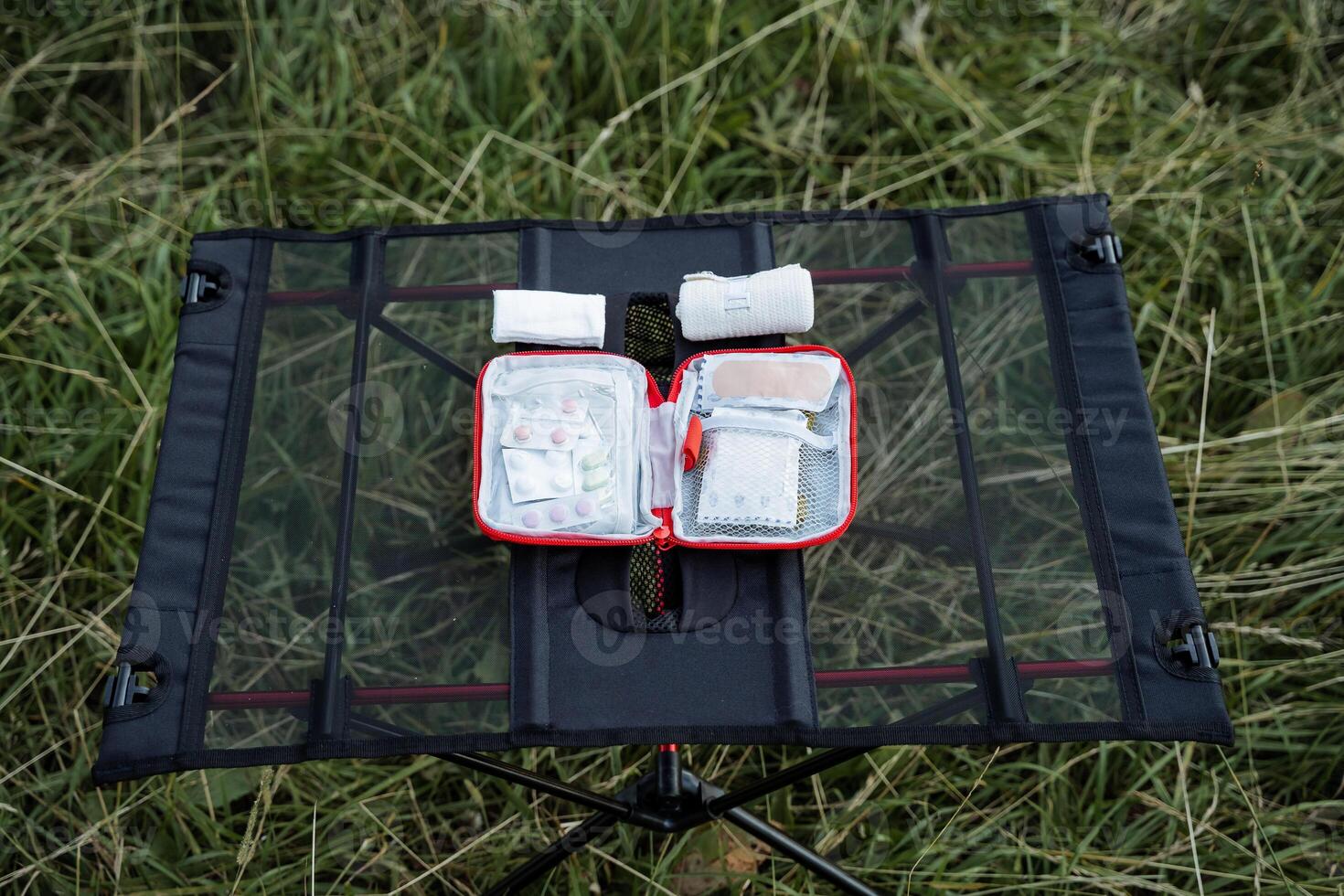 een klein eerste steun uitrusting in de Woud, een toerist reeks van tablets Aan de weg, een camping samenstelling van een eerste hulp uitrusting. geneesmiddelen zijn Aan de tafel tegen de achtergrond van gras foto