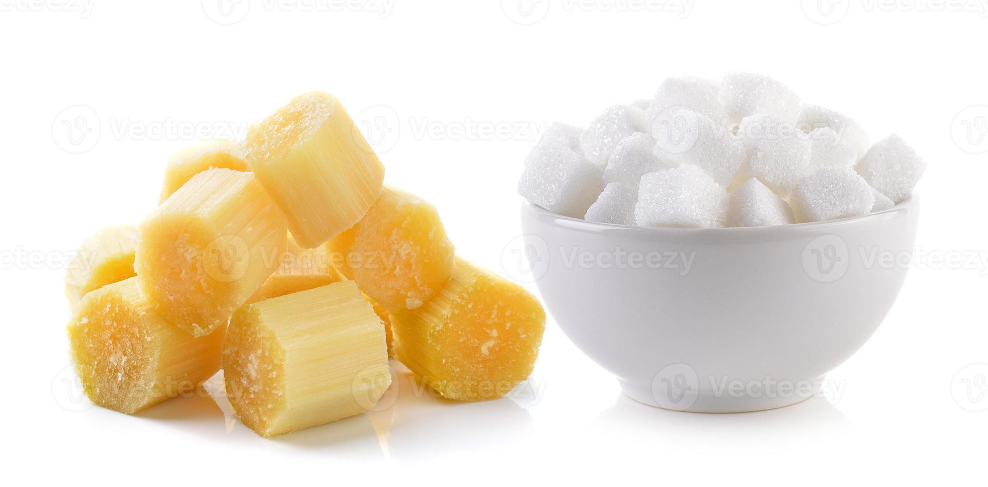suikerklontje in de kom en suikerriet op witte achtergrond foto