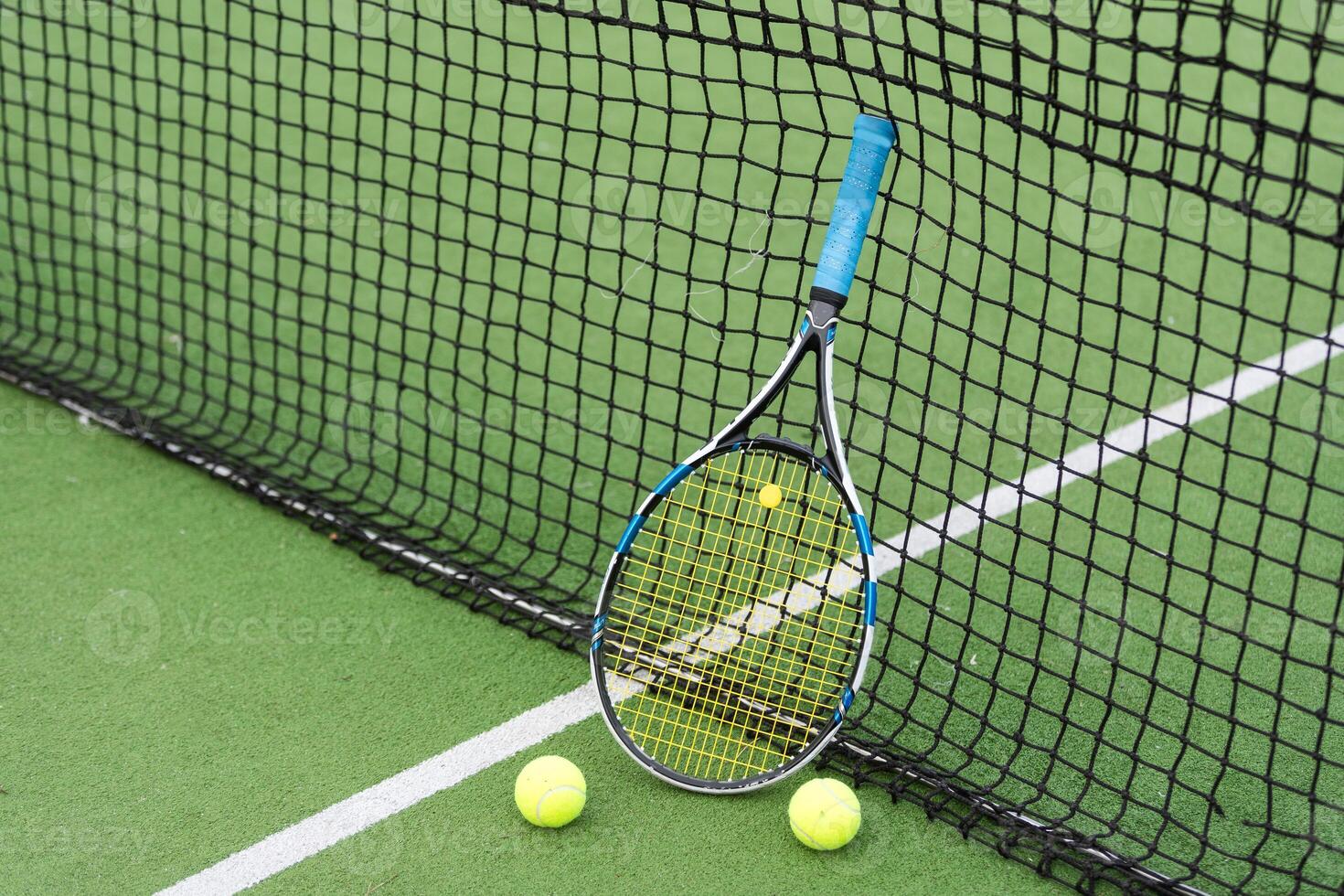 tennis racket en tennis bal Daarnaast de netto Aan buitenshuis tennis rechtbank. foto