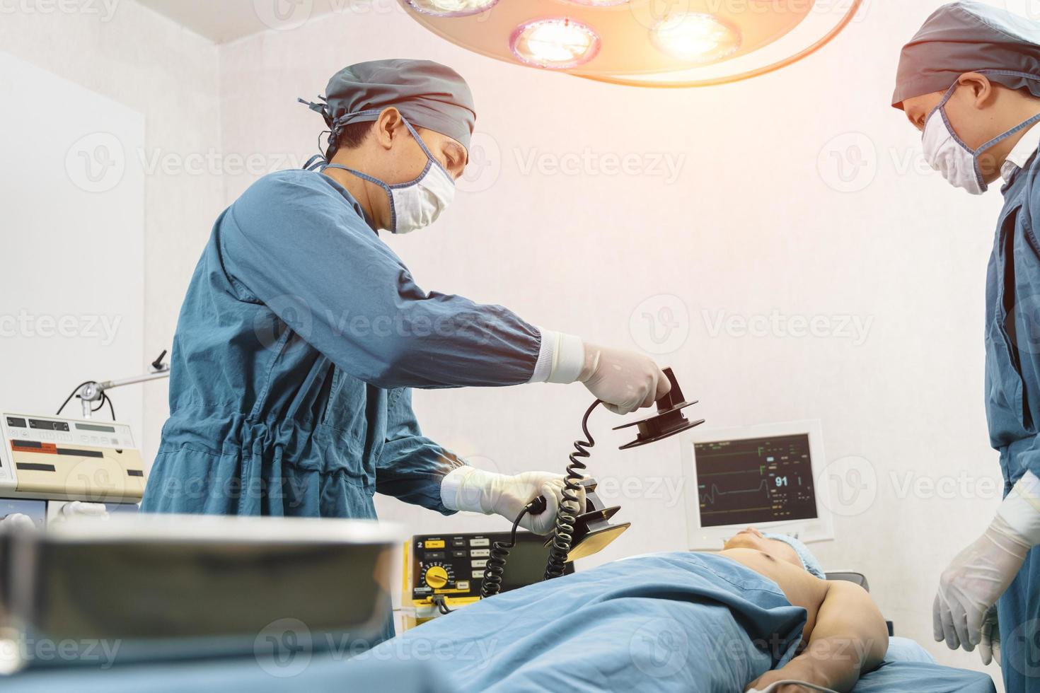 chirurg en assistent maken reanimatie op de patiënt in de operatiekamer. eerste hulp nood- cardiopulmonale reanimatie foto