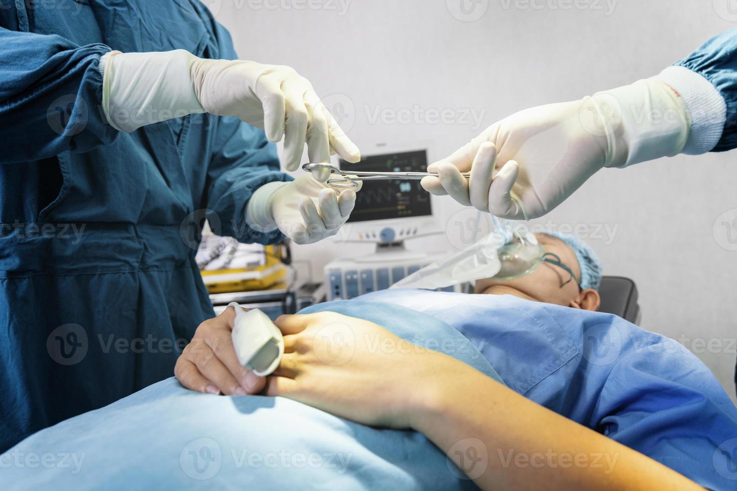 assistent deelt instrumenten uit aan chirurgen tijdens operatie. chirurgie en noodconcept foto