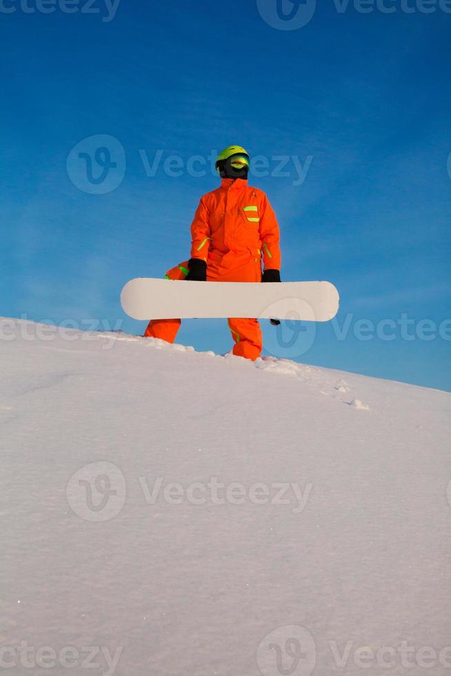 snowboarder freerider met wit snowboard op de top van de skipiste foto