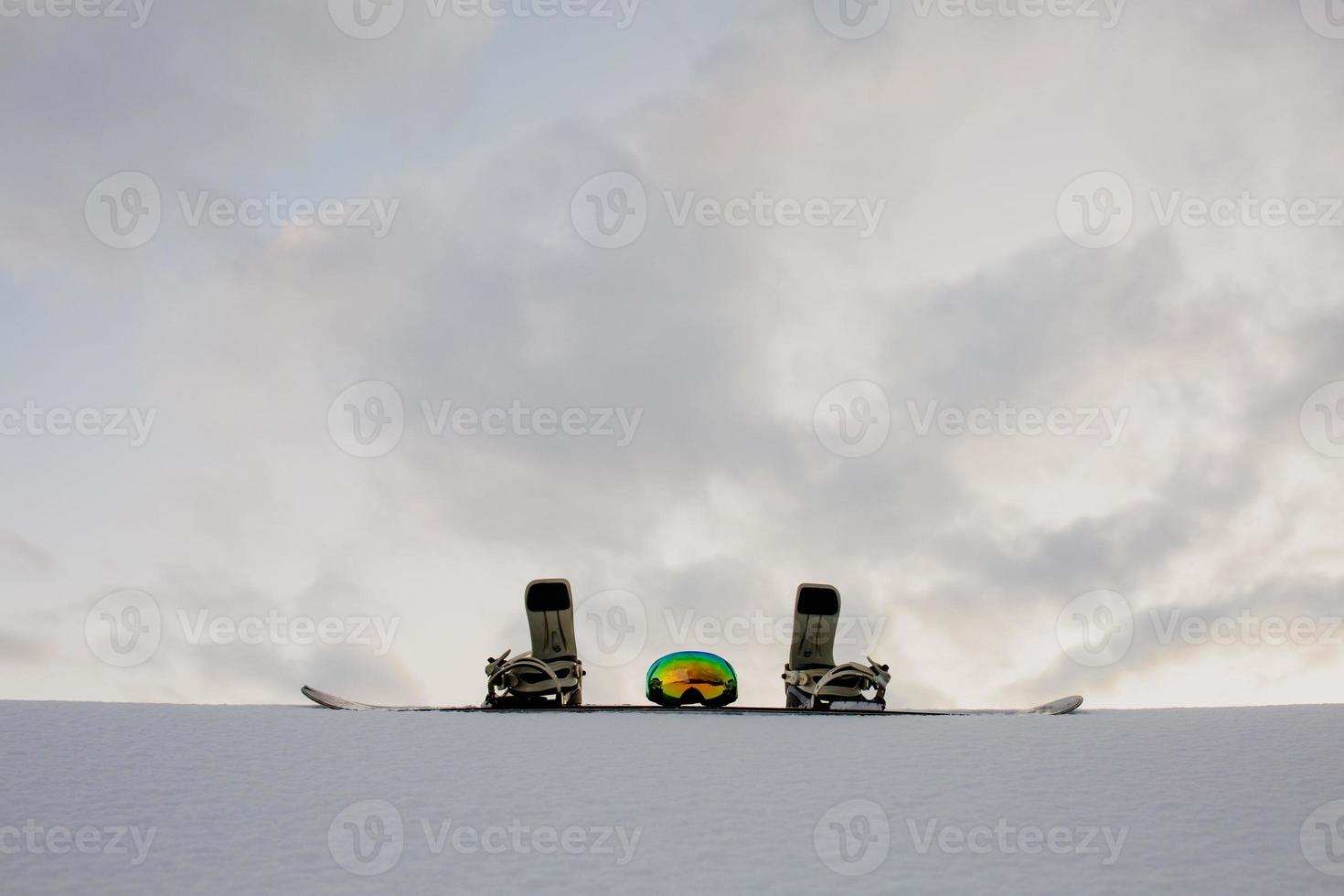 poedertextuur en uitrusting voor snowboarden bij zonsondergang foto