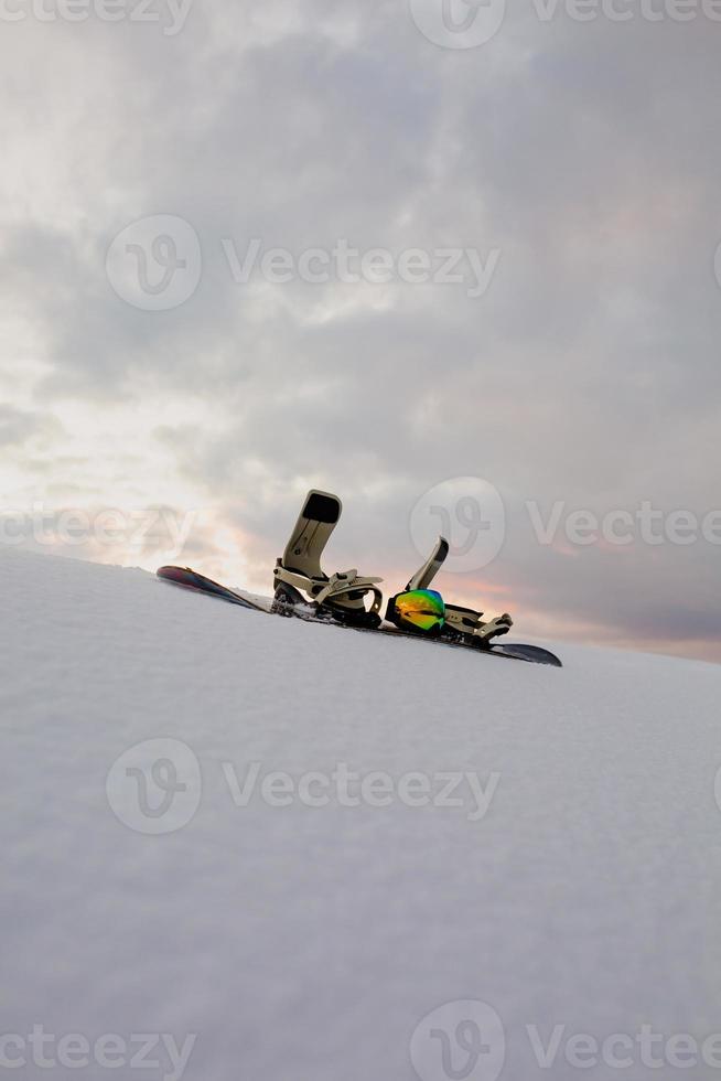 poedertextuur en uitrusting voor snowboarden bij zonsondergang foto