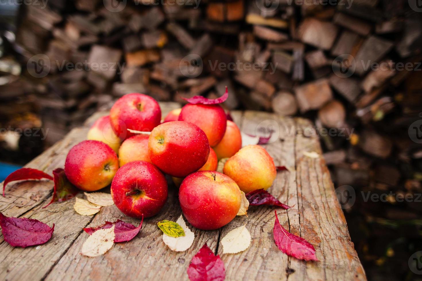 stilleven met verschillende rode appels liggend op een oude houten tafel foto