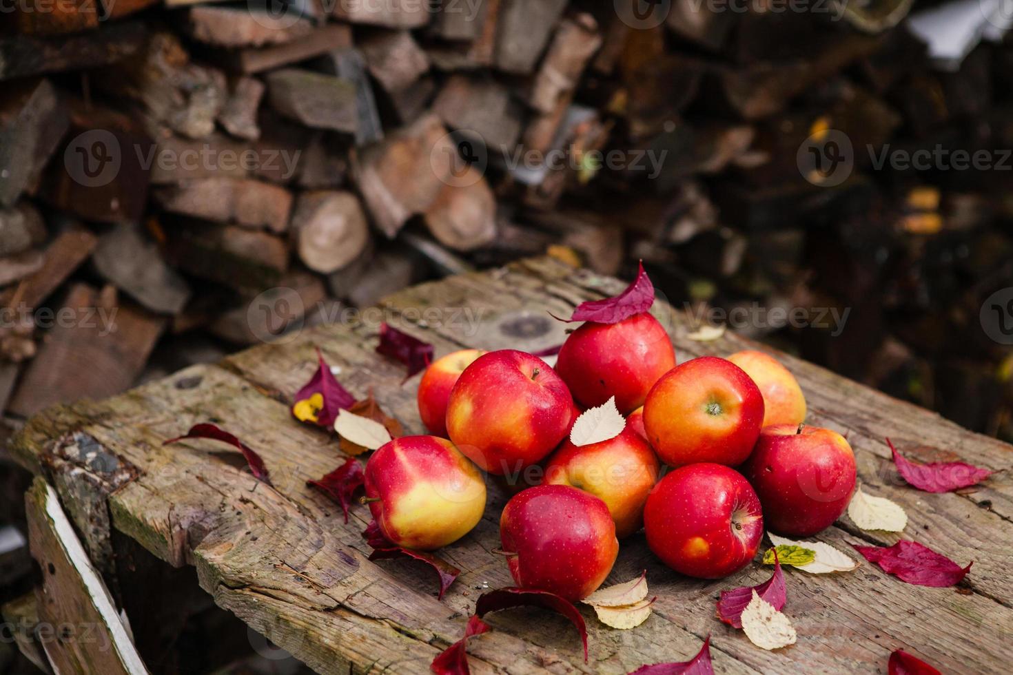 stilleven met verschillende rode appels liggend op een oude houten tafel foto