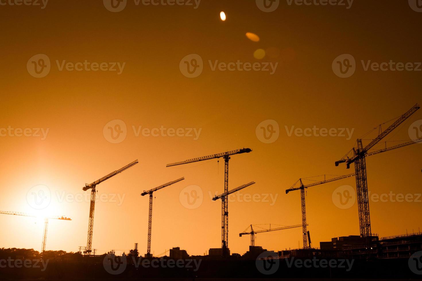 kraansilhouet van een grote bouwplaats foto