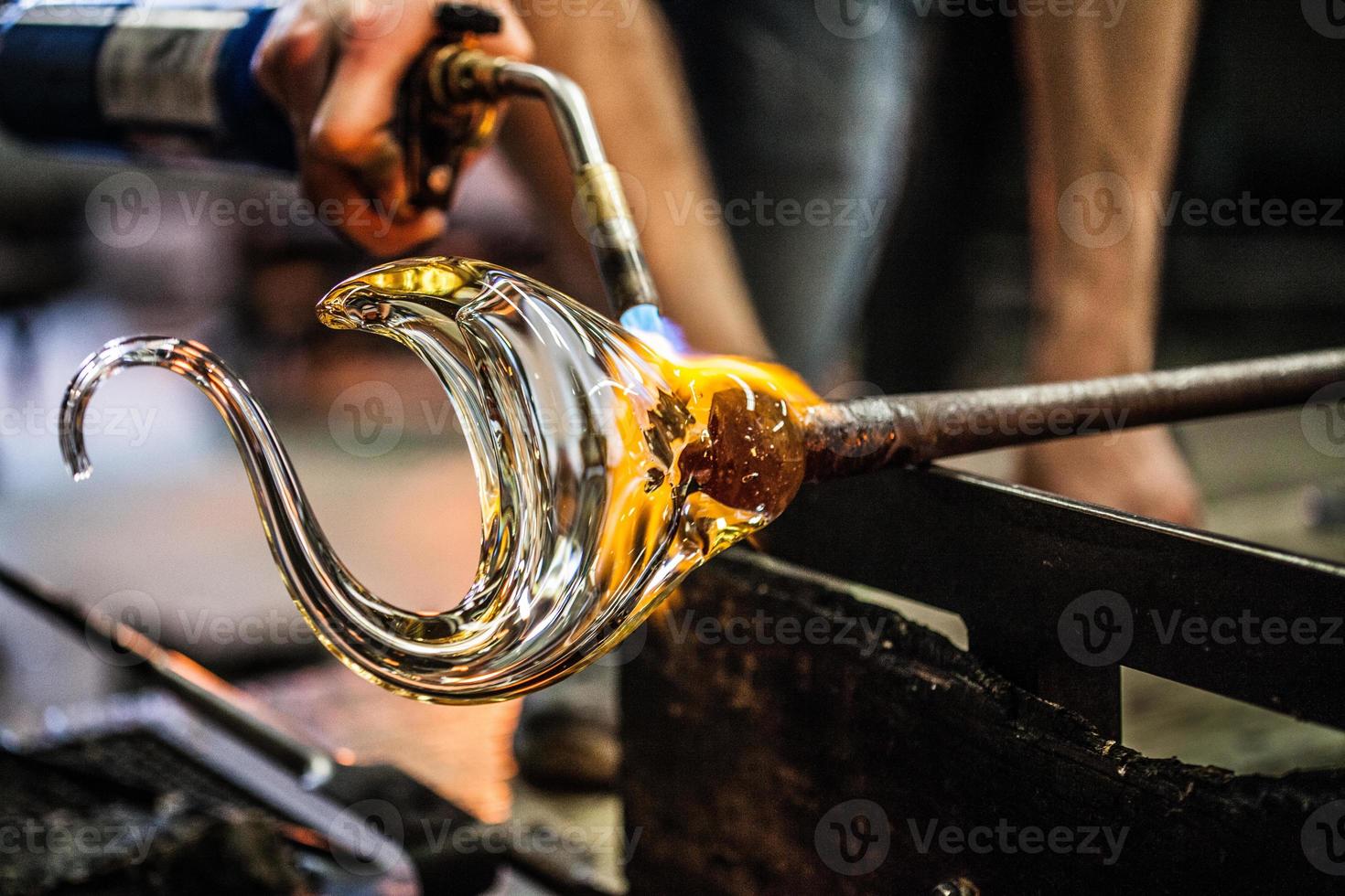 man handen close-up werken aan een stuk geblazen glas foto