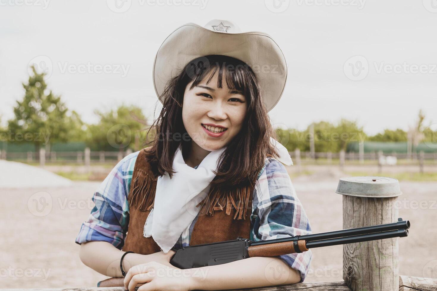 portret van een mooi Chinese vrouw veedrijfster het schieten met een wapen foto