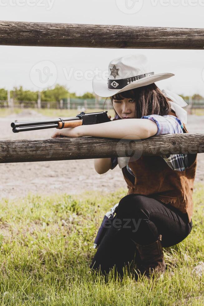 portret van een mooi Chinese vrouw veedrijfster het schieten met een wapen foto